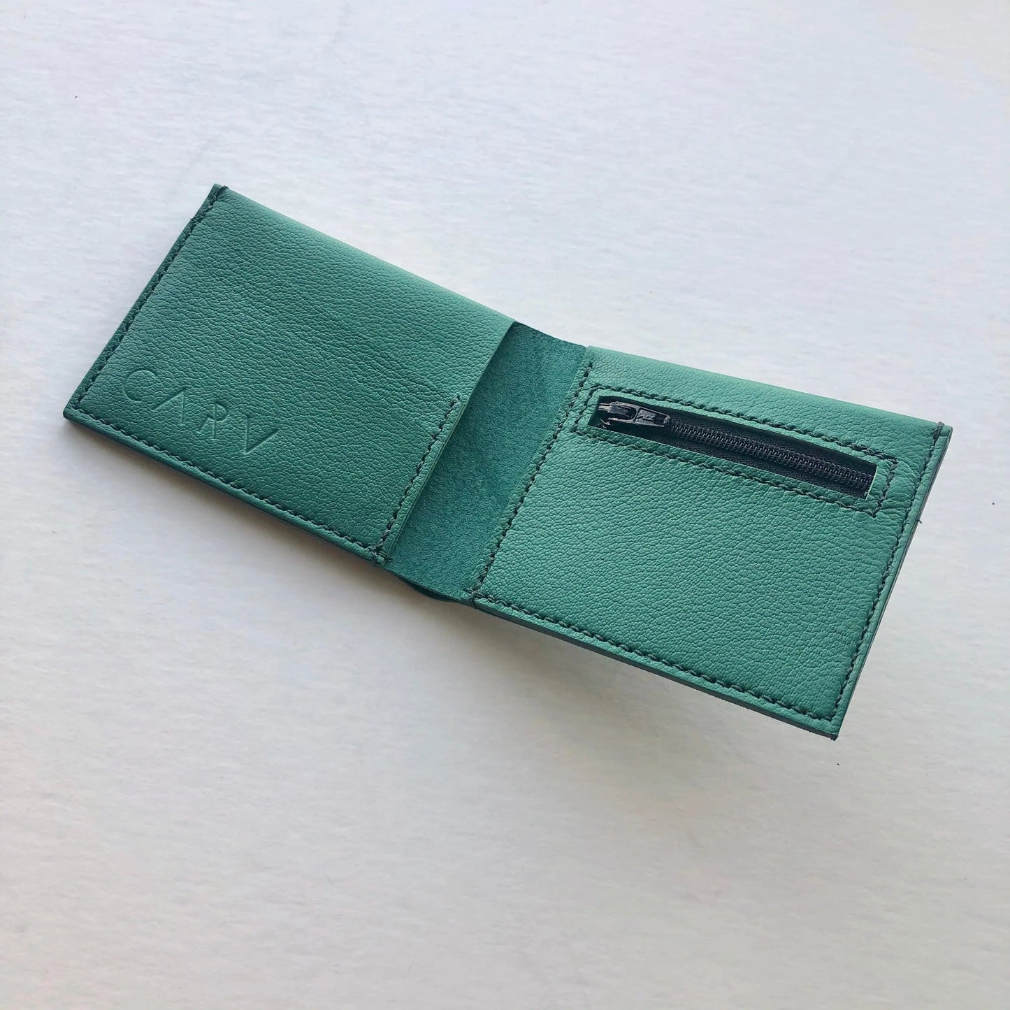 Green men's leather wallet by CARV in minimalist design with zip coin pocket and textured leather