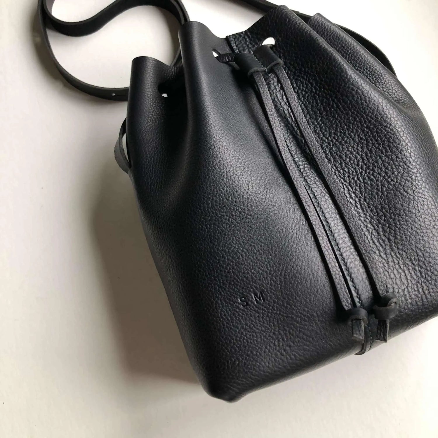 CARV personalised leather bucket bag in black with duffle style drawstring
