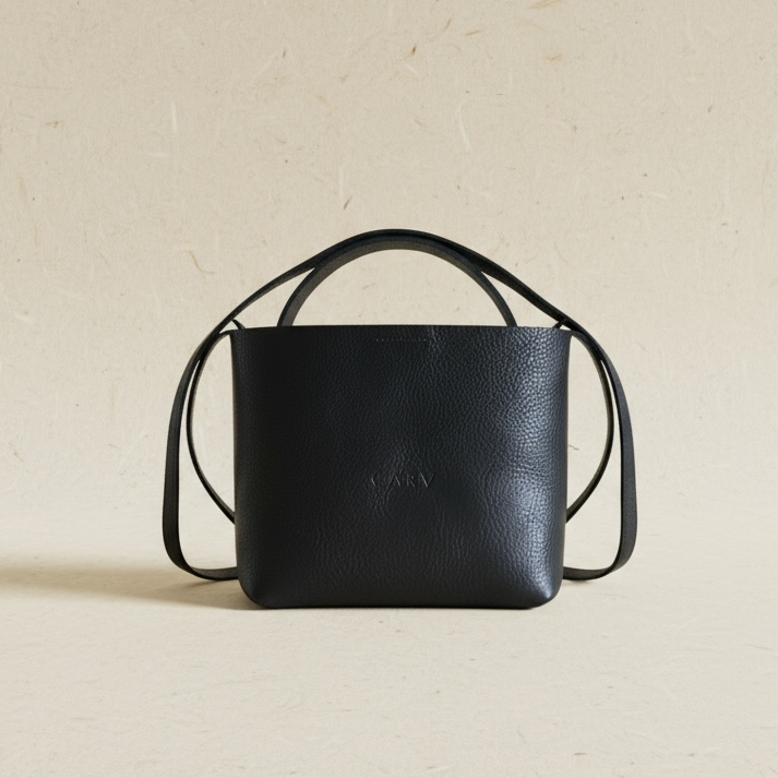 Black leather handbag on a beige background