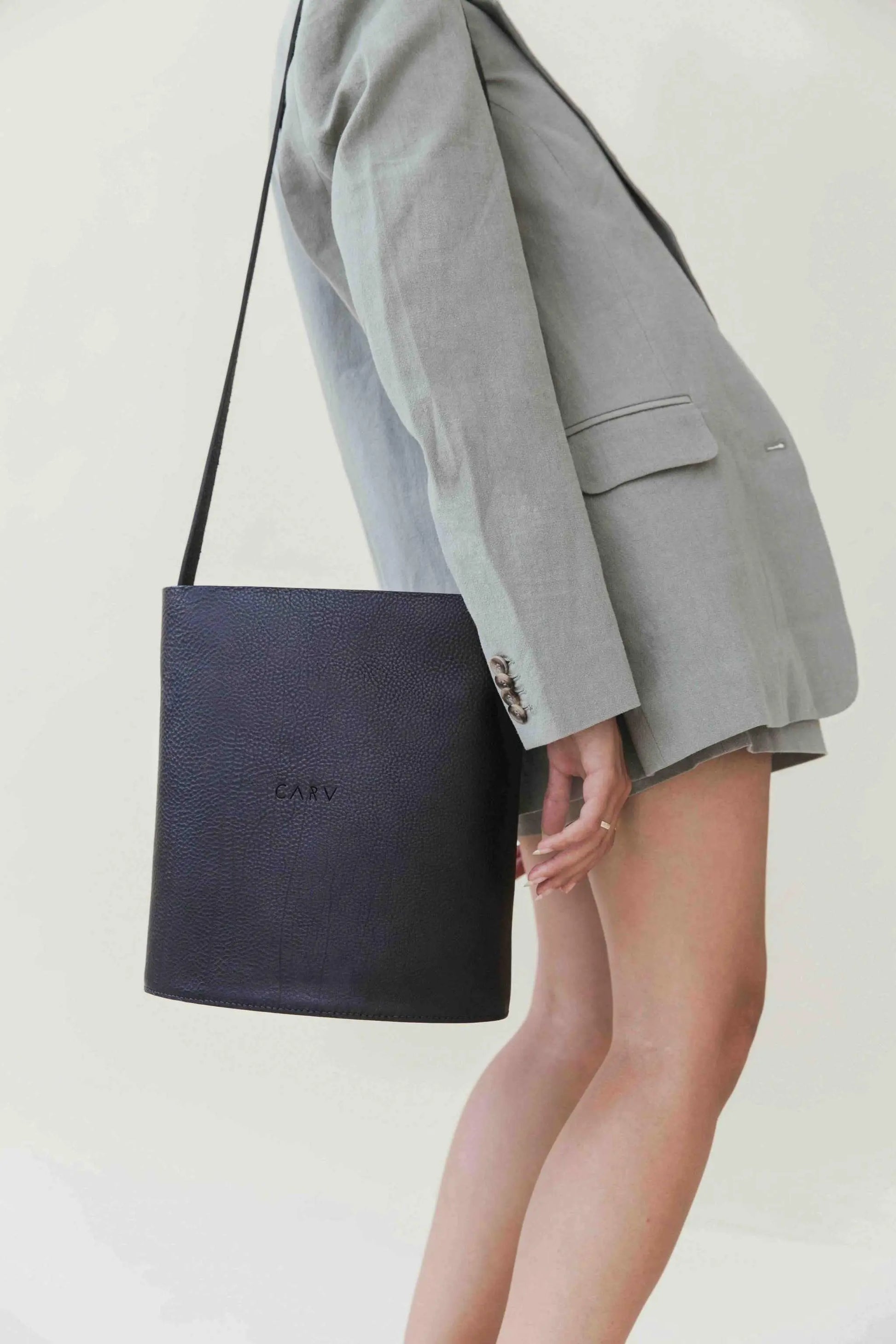 Oval Maxi Leather Bag in black, handcrafted in the UK from vegetable-tanned leather, shown on model with adjustable strap.