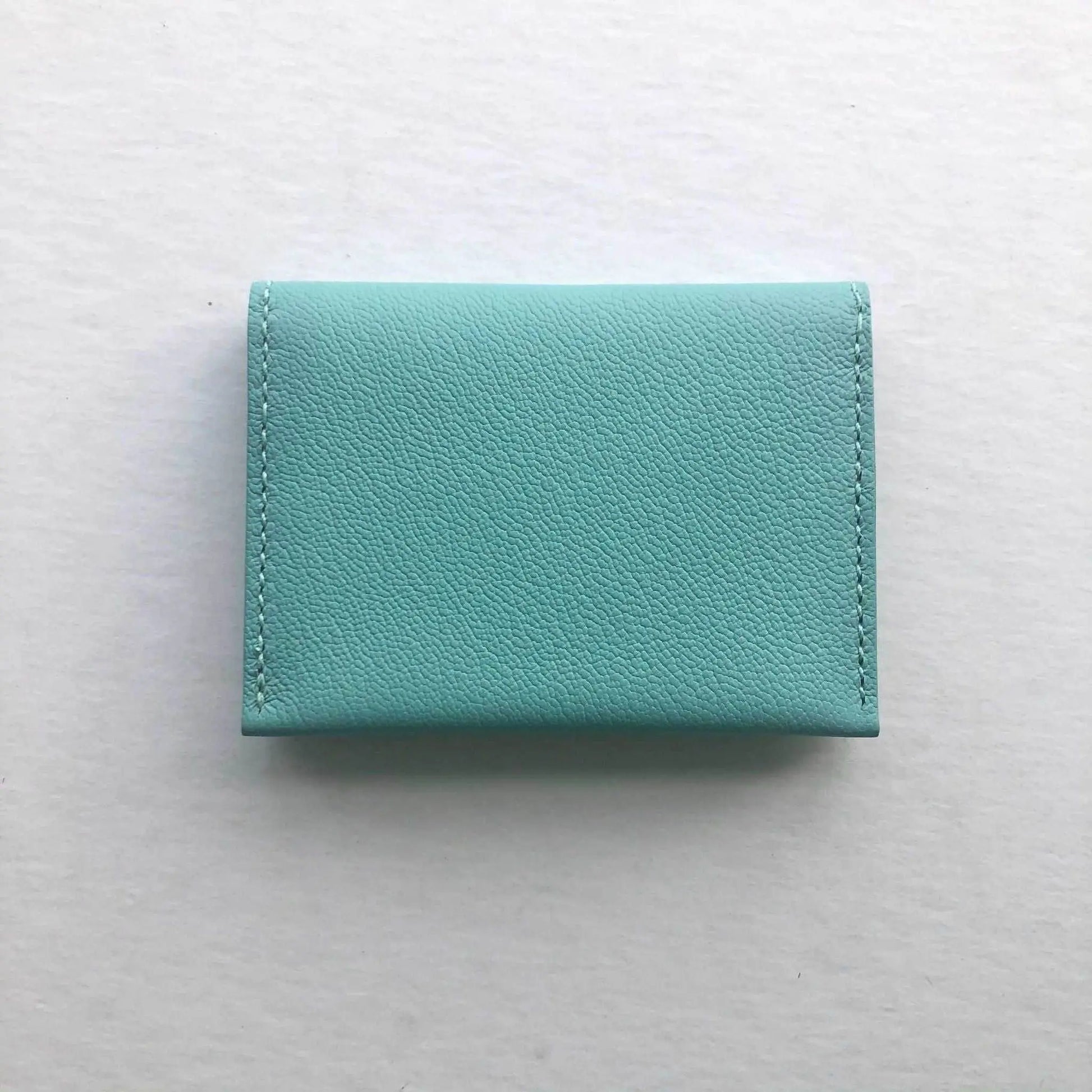 Turquoise leather card wallet, handcrafted bifold design with minimalist style.