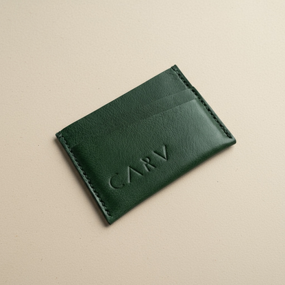 Green leather cardholder with 'CARV' branding on a beige background