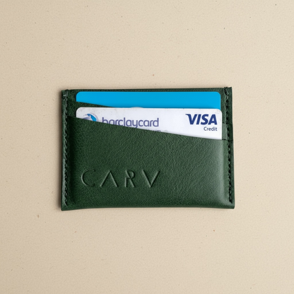 Green leather cardholder with Barclays and Visa cards on a beige background