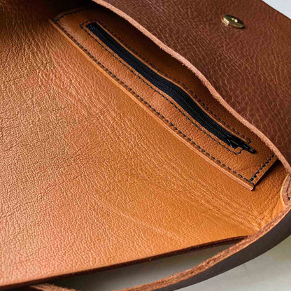 Tan Drifter Leather Crossbody Bag with zip pocket and brass closure.